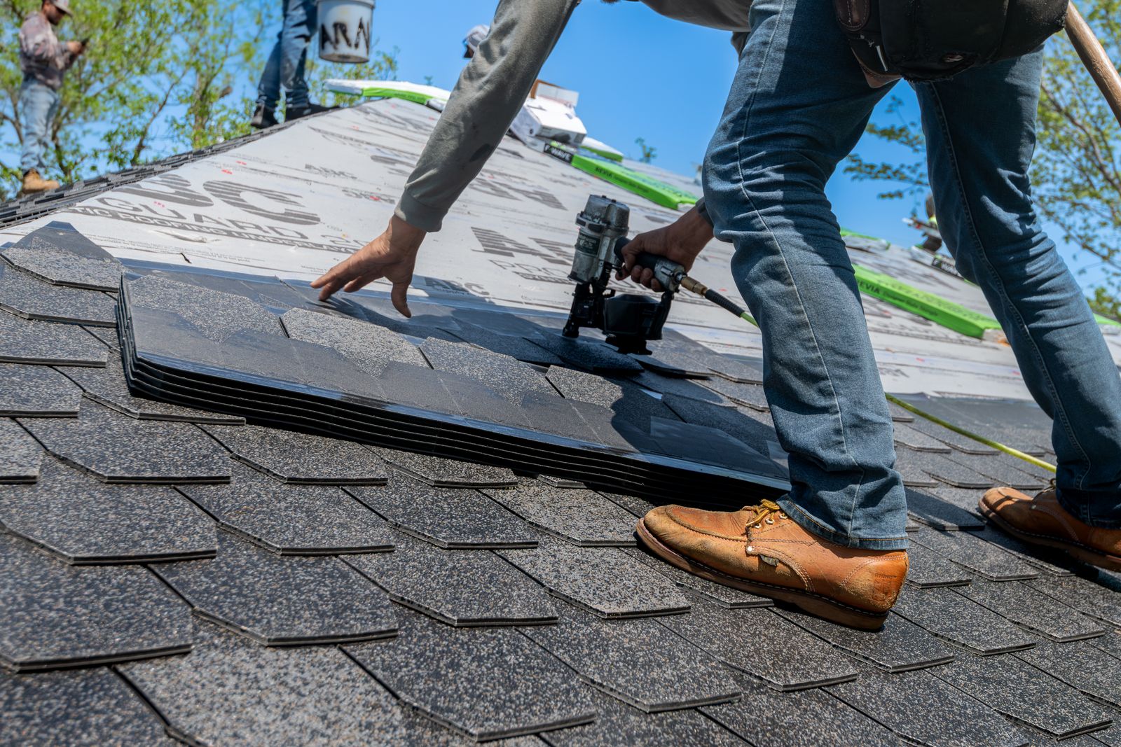 Professional roofer installing architectural shingles on a residential roof